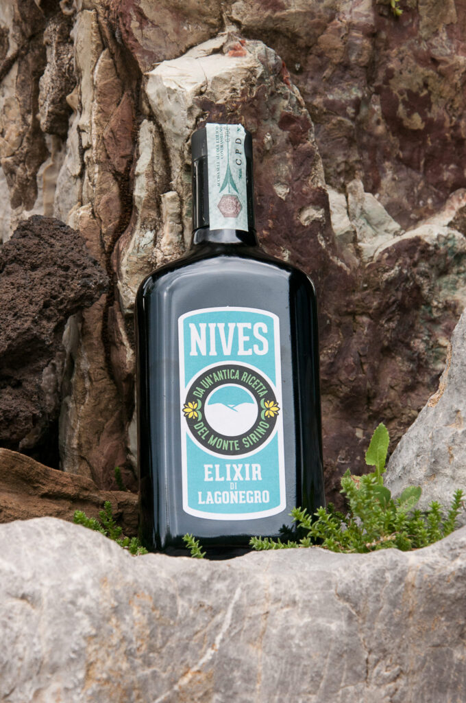 Bottiglia di Nives Elixir ambientata tra le rocce